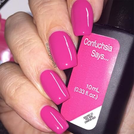Mano con uñas rosas intenso Confuchsia Says sujetando frasco de esmalte de gel para uñas semipermanentes
