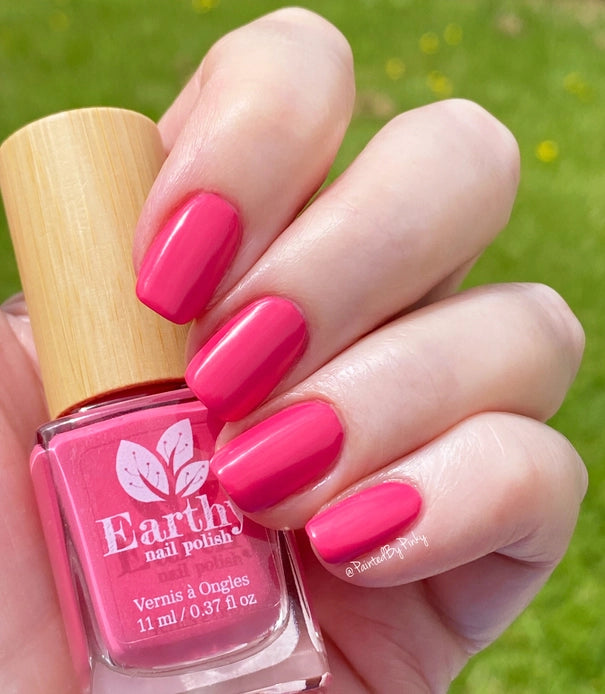 Mano de mujer con las uñas rosas Orquídea naturales y brillantes del esmalte de uñas sin tóxicos de Mother Nailture