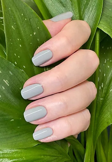 Mano de mujer con las uñas grises Gris Tormenta naturales y brillantes del esmalte de uñas sin tóxicos de Mother Nailture
