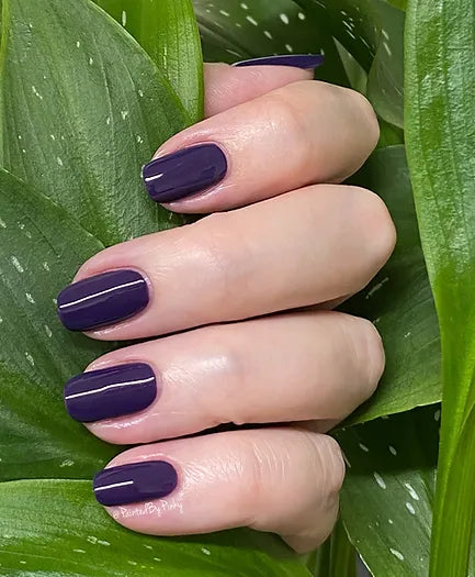 Mano de mujer con las uñas azules lavanda Jacaranda naturales y brillantes del esmalte de uñas sin tóxicos de Mother Nailture