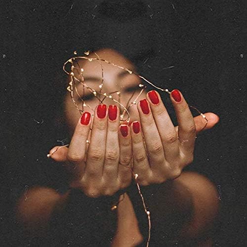 Mujer con manos extendidas con uñas rojas del esmalte de gel para uñas semipermanentes Spoiled Diva sujetando luces