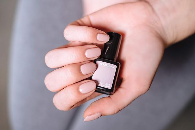 Mano con uñas nude Nude Mood sujetando frasco de esmalte de gel para uñas semipermanentes de Sensationail