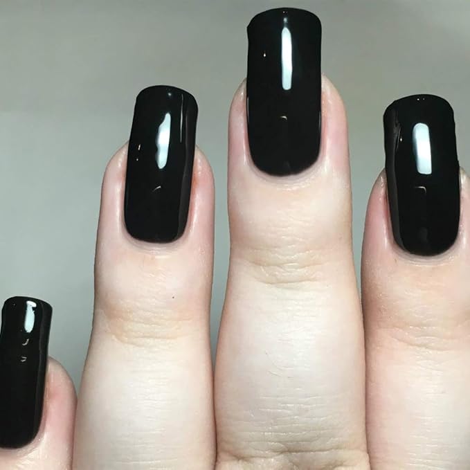 Dedos de mujer con uñas negras del esmalte de gel I’m the Black Sheep